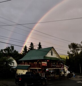 The barn behind the store is collapsing, as this rainbow lights up the sky. 